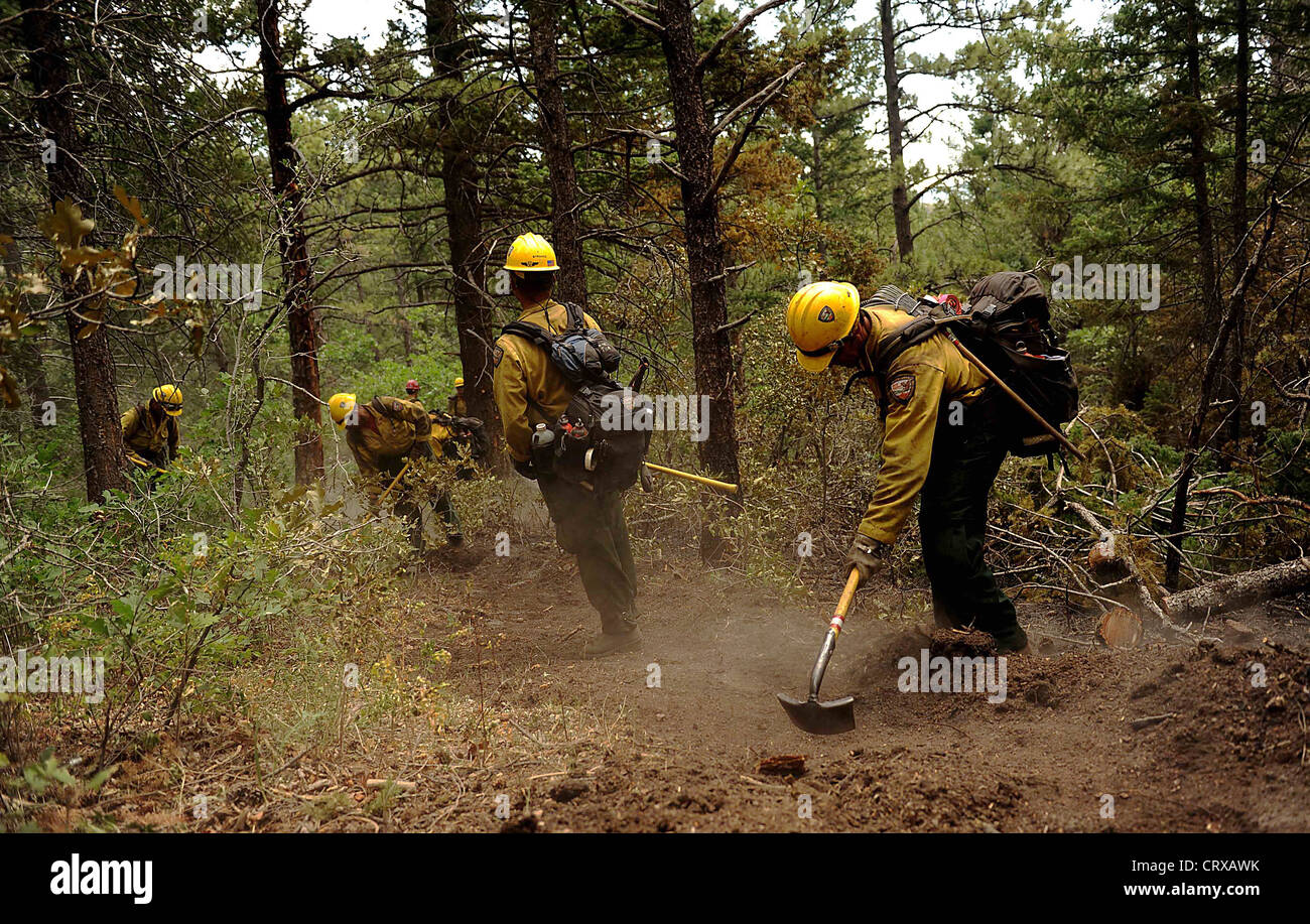 A US Forest Service Hot Shot firefighter crew clears a fire line to slow the Waldo Canyon wild fire in the Mount St. Francis June 28, 2012 in Colorado Springs, CO. Stock Photo