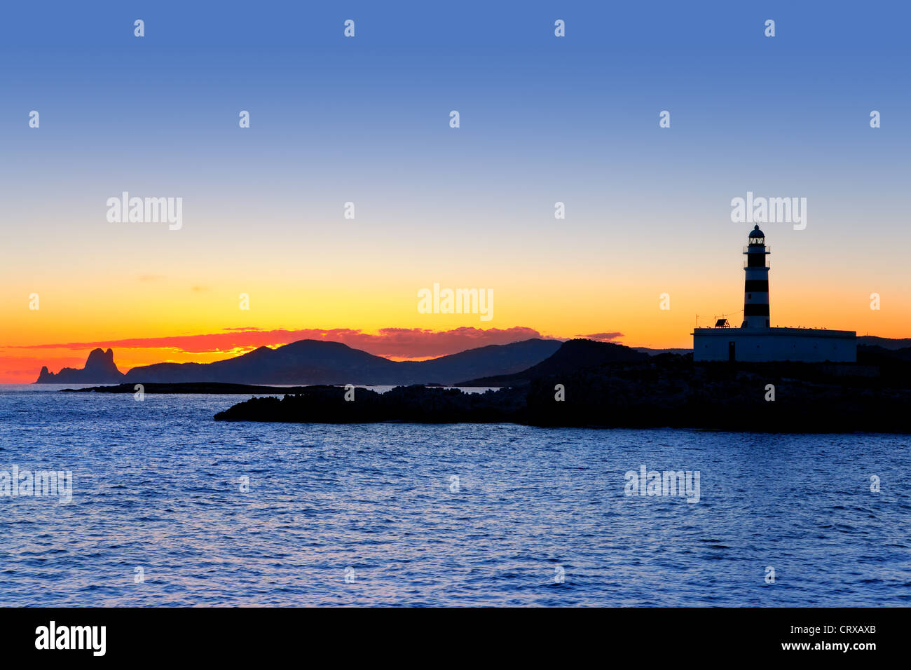 Ibiza island sunset with freus lighthouse and Es Vedra in background Stock Photo