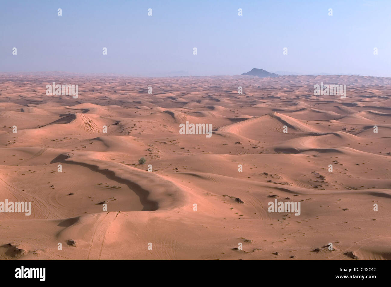 Four-wheel drive tracks across rippled desert sand dunes, seen from a ...