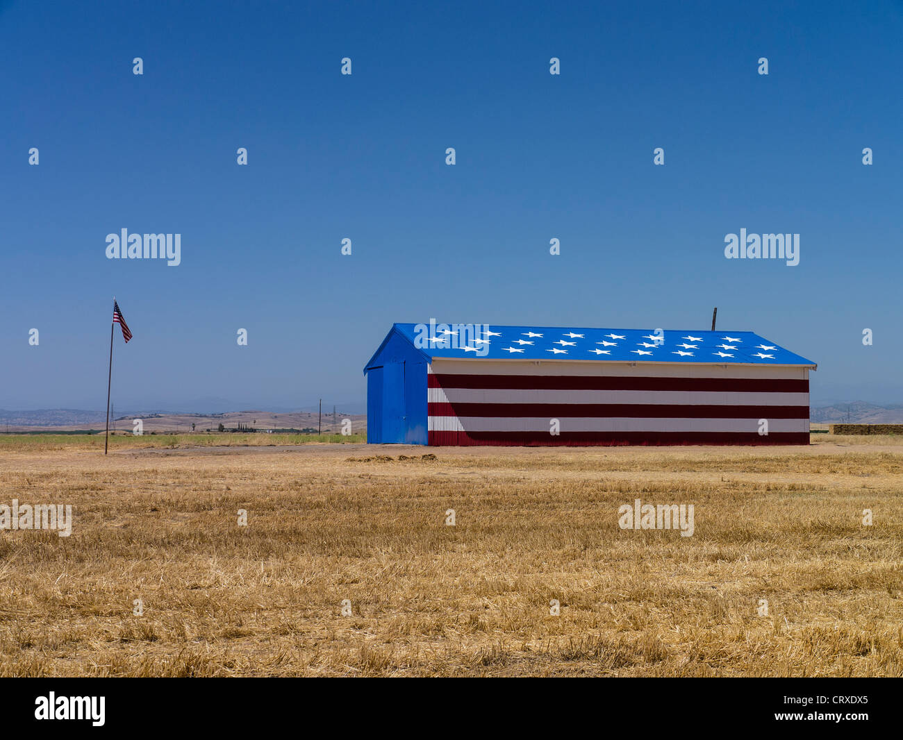 A rural Central Valley of California barn painted with stars and stripes to resemble the flag of the United States of America. Stock Photo