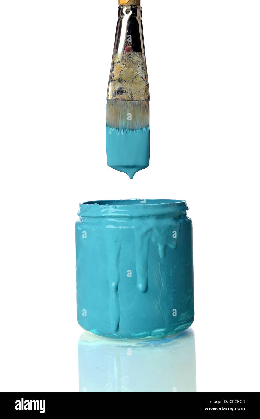 Old brush dripping teal paint into can of teal paint isolated over white background Stock Photo