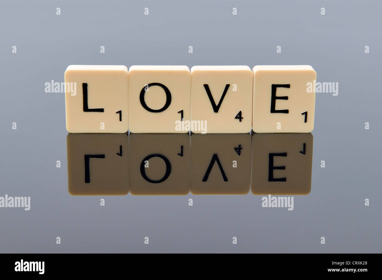 Scrabble letters spelling out the word love with reflection, concept of love or valentine Stock Photo