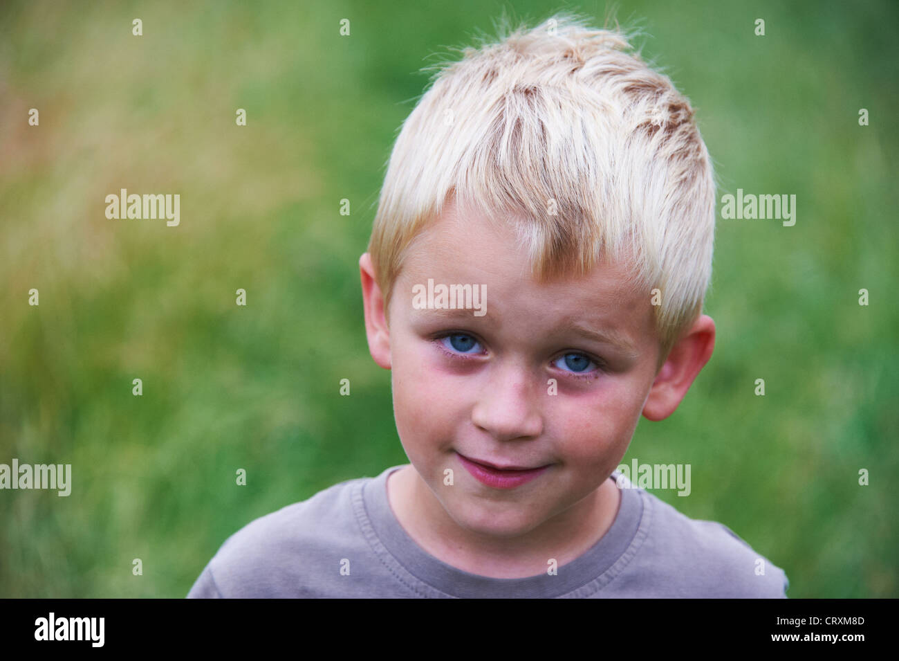 portrait-of-smiling-boy-5-6-years-old-with-blond-hair-outside-stock