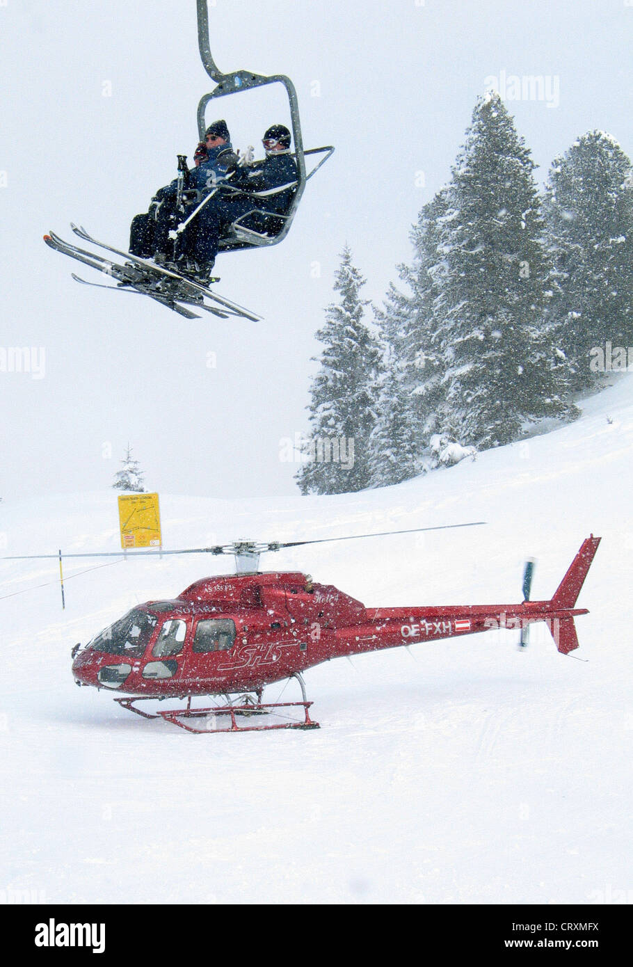 Skiers and rescue helicopter in a snowstorm Stock Photo