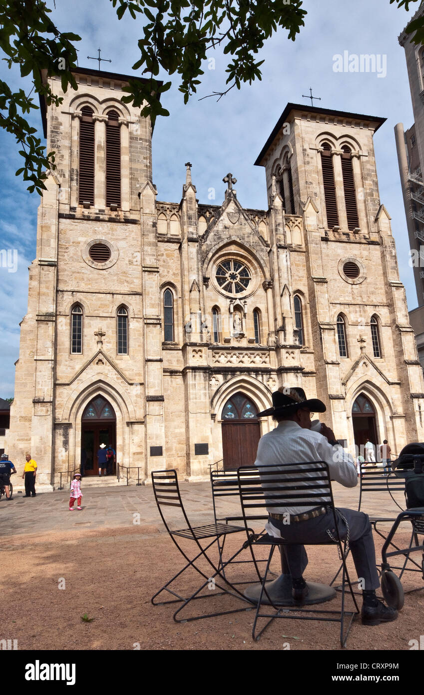 Man sitting at table in front of San Fernando Cathedral on Main Plaza in San Antonio, Texas, USA Stock Photo