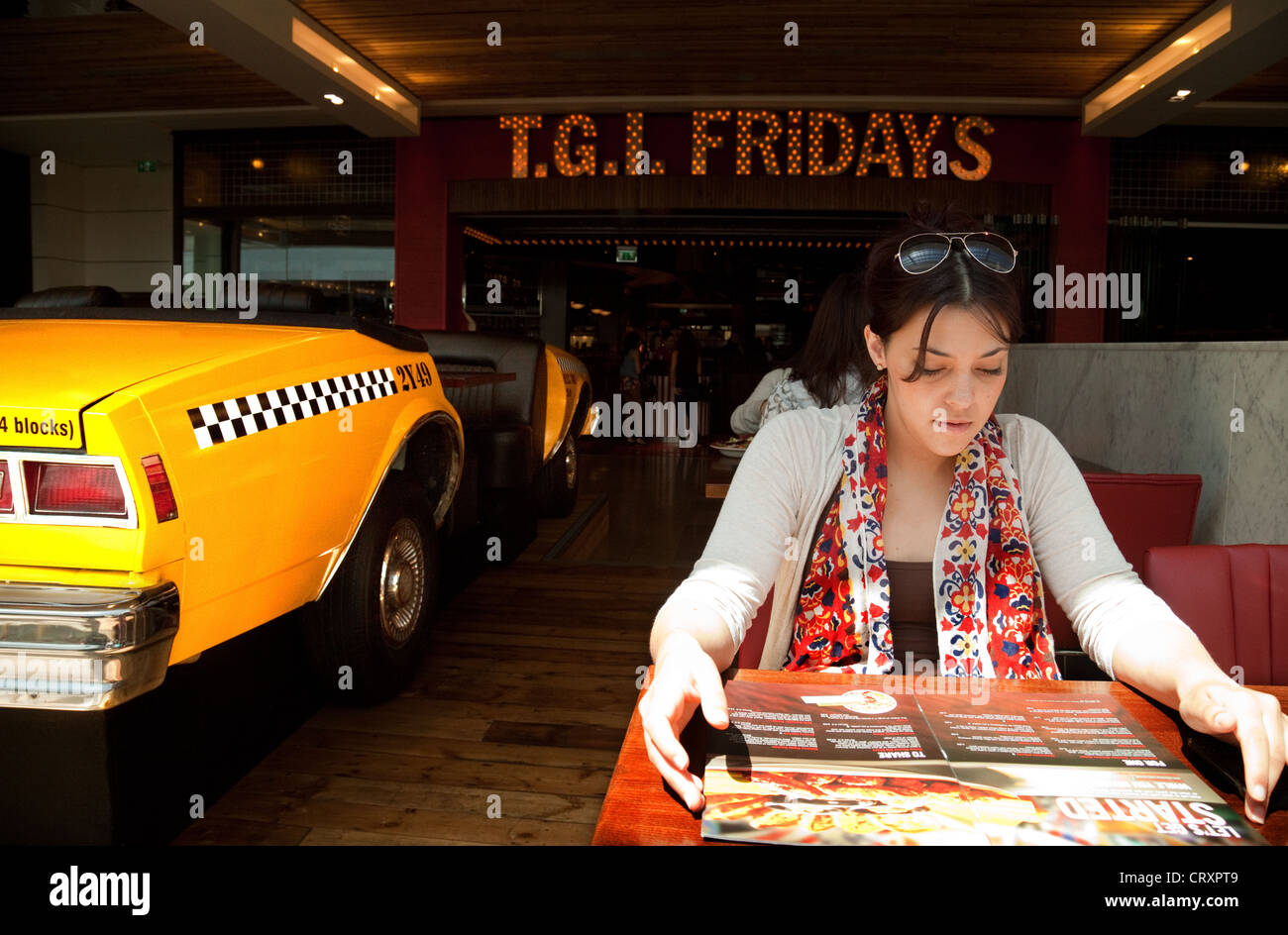 Teen girl eating in TGI Fridays Restaurant, Westfield Shopping Centre, Stratford London UK Stock Photo