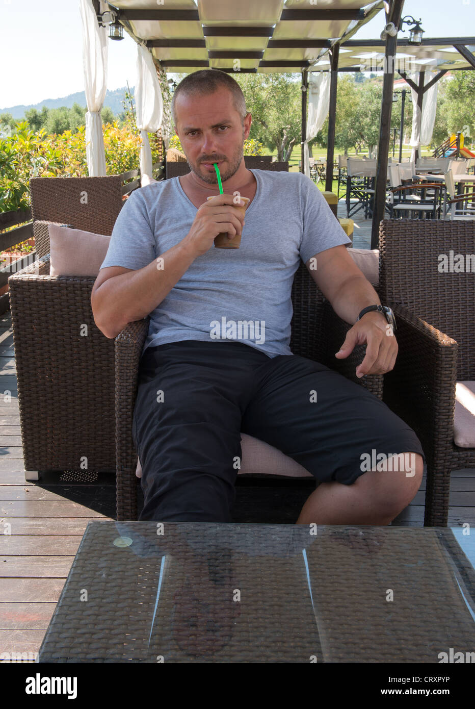 Greek man relaxing and drinking a Frappe Stock Photo