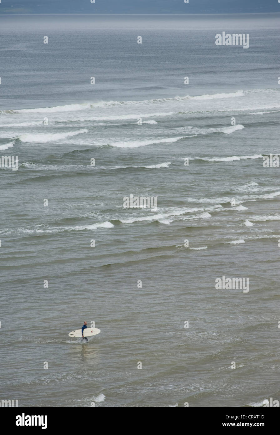 Surfer leaving the sea at Bundoran, County Donegal. Stock Photo