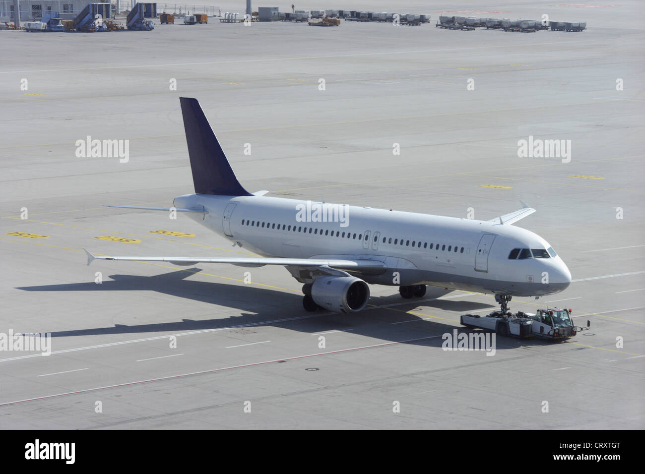 Europe, Germany, Bavaria, Aircraft tractor, pusher and commercial passenger plane at Munich airport Stock Photo