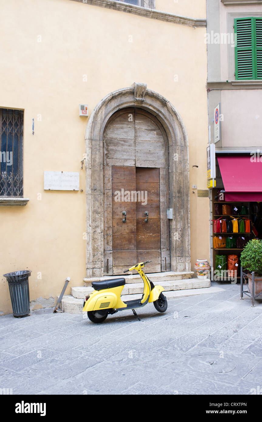 Yellow Vespa motor scooter parked in street in Montepulciano Italy Stock Photo