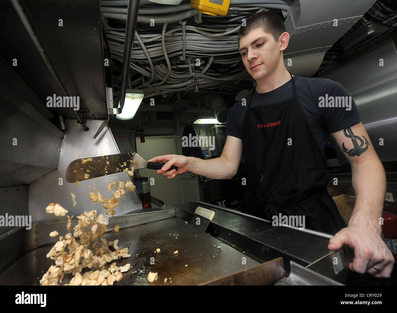 Culinary Specialist 3rd Class Chad P. Smith prepares lunch in the commanding officer’s in-port cabin aboard the Nimitz-class aircraft carrier USS Abraham Lincoln (CVN 72). Lincoln is deployed to the U.S. 5th Fleet area of responsibility conducting maritime security operations, theater security cooperation efforts and combat flight operations in support of Operation Enduring Freedom. Stock Photo
