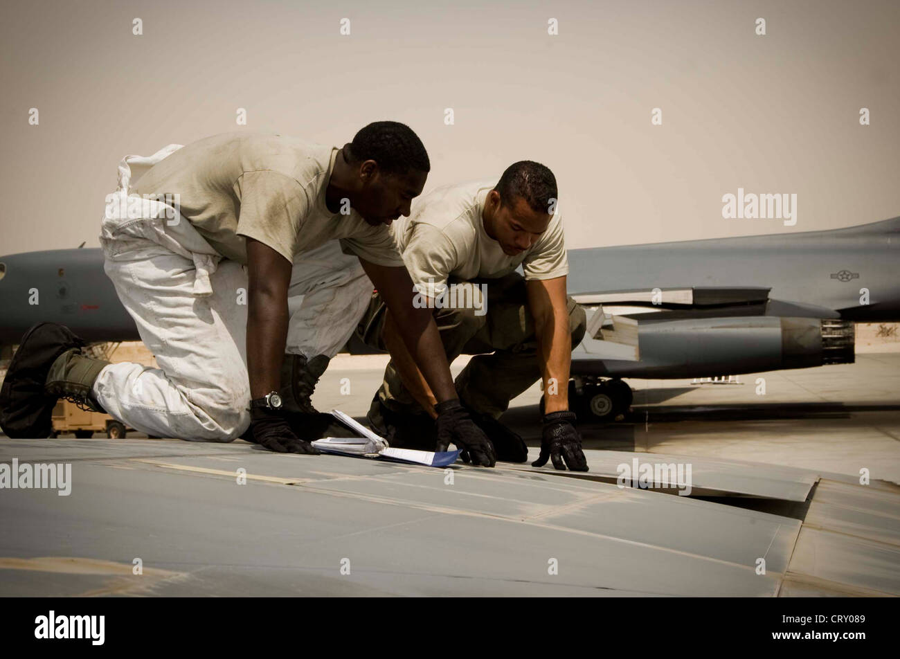 U.S. Air Force Senior Airman Brandon Wharton (foreground), crew chief, and Senior Airman Robert Farris, electrical technician, inspect the spoiler of a B-1 Lancer during a routine post-flight inspection in Southwest Asia, July 2, 2012. Both Airmen are assigned to the 379th Expeditionary Aircraft Maintenance Squadron and are deployed from Dyess Air Force Base, Texas. Wharton is a native of Huntsville, Ala., and Farris is from Killen, Texas. Stock Photo