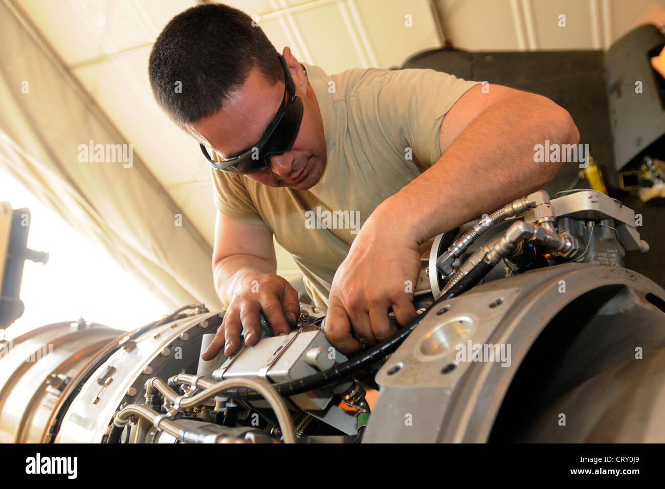 U.S. Army Sgt. Michael Johnson, an engine mechanic, works on the engine for a CH-47 Chinook at Kandahar Airfield, Afghanistan on July 3, 2012. Johnson, a native of Riverside, Calif., is currently deployed to Afghanistan with Delta Company, 3rd Battalion, 25th Aviation Regiment out of Wheeler Army Airfield, Hawaii. Stock Photo