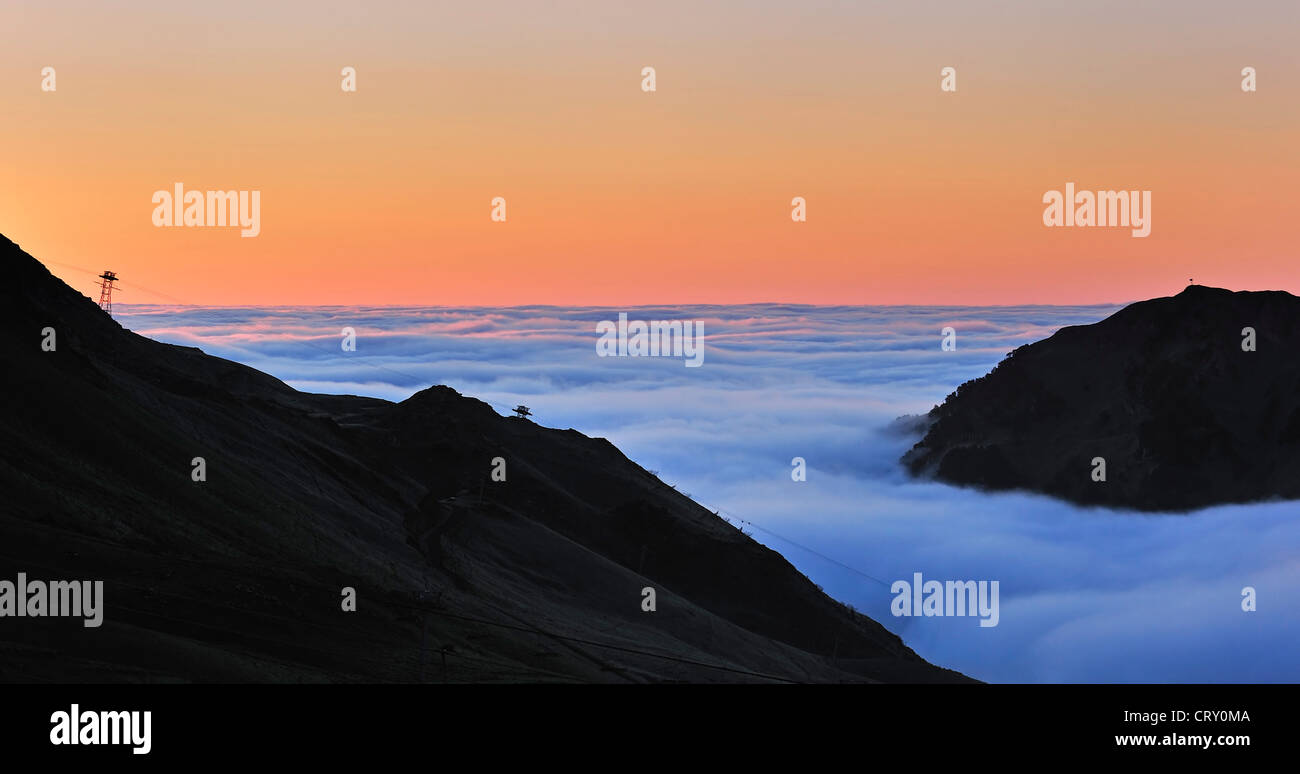 View over mountains covered in mist at sunrise seen from the mountain pass Col du Tourmalet, Hautes-Pyrénées, Pyrenees, France Stock Photo