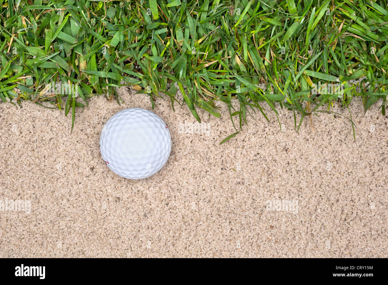 A golf ball in a sand trap next to the rough highlights the mistakes
