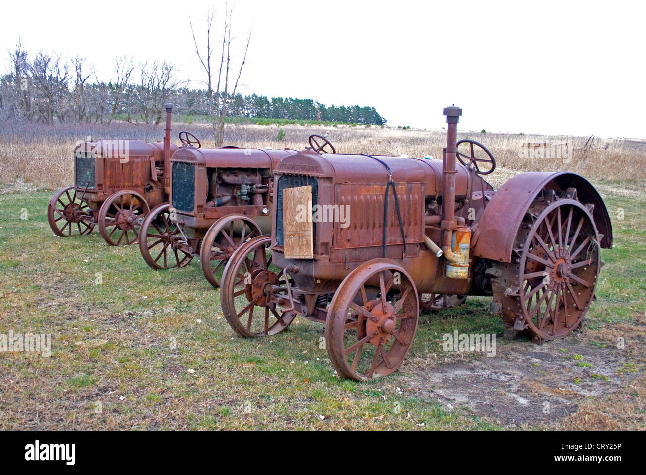 Row of antique tractors on display near a farm. Ottertail Minnesota MN USA Stock Photo