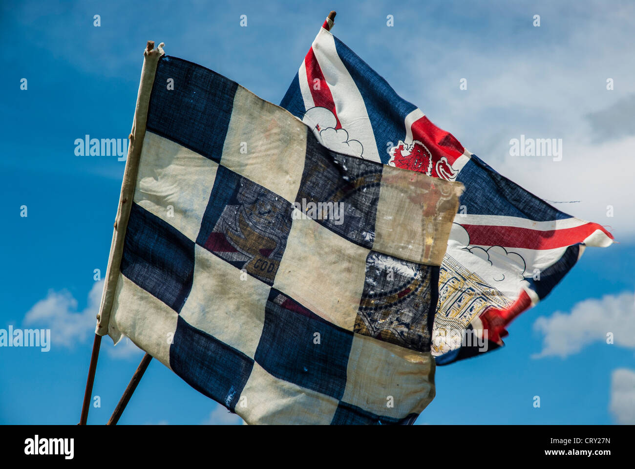 flags blowing in the wind against a blue and white sky Stock Photo