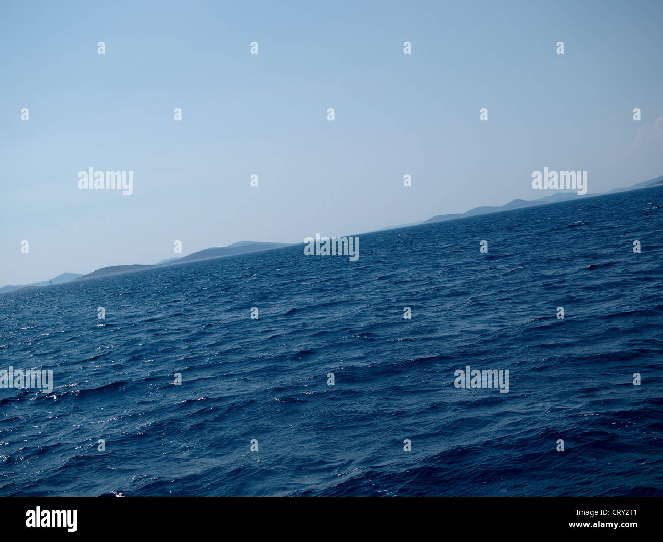 Deep blue sea surface with distant islands on horizon Stock Photo