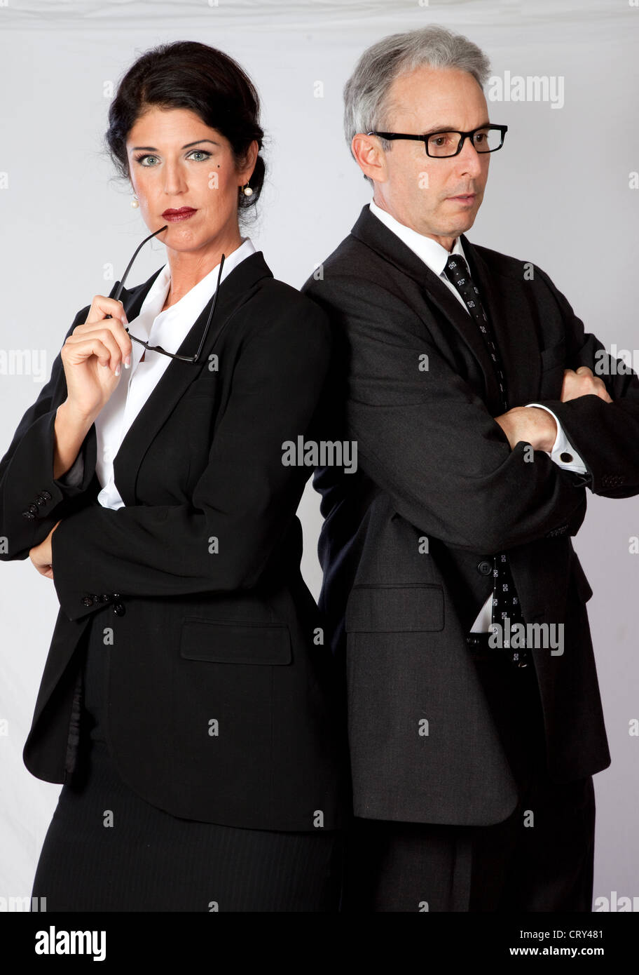 couple in business suits standing together with hands in pockets on white  background Stock Photo - Alamy
