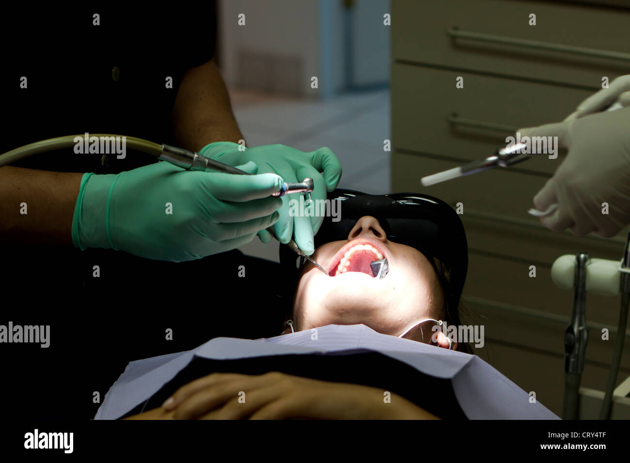 dentist treating a cavity while the patient is watching a movie Stock Photo