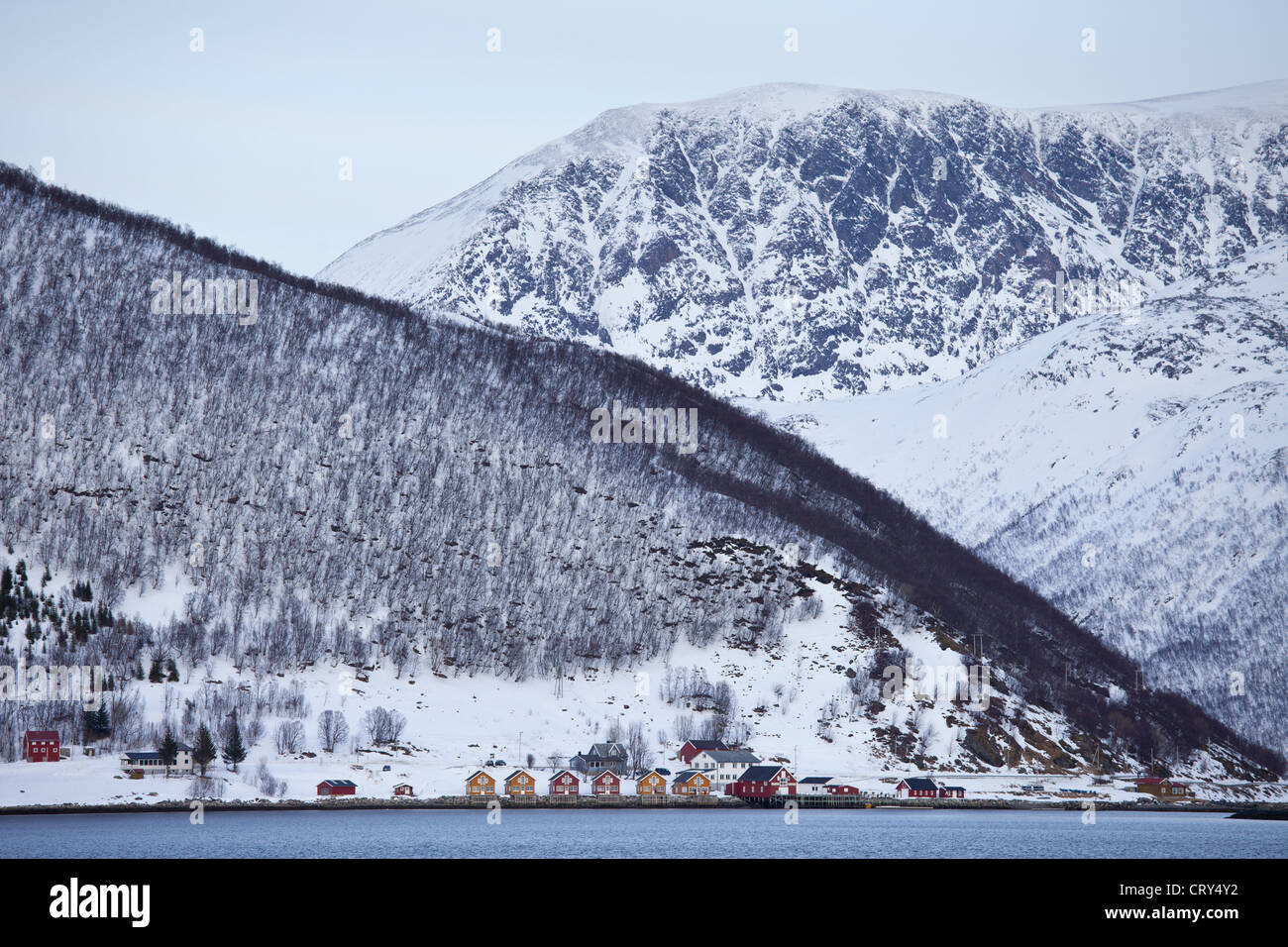 Homes and fishing huts in hamlet across fjord from Sandneshamnvegen 862 on Kvaloya Island, Tromso, Arctic Circle Northern Norway Stock Photo