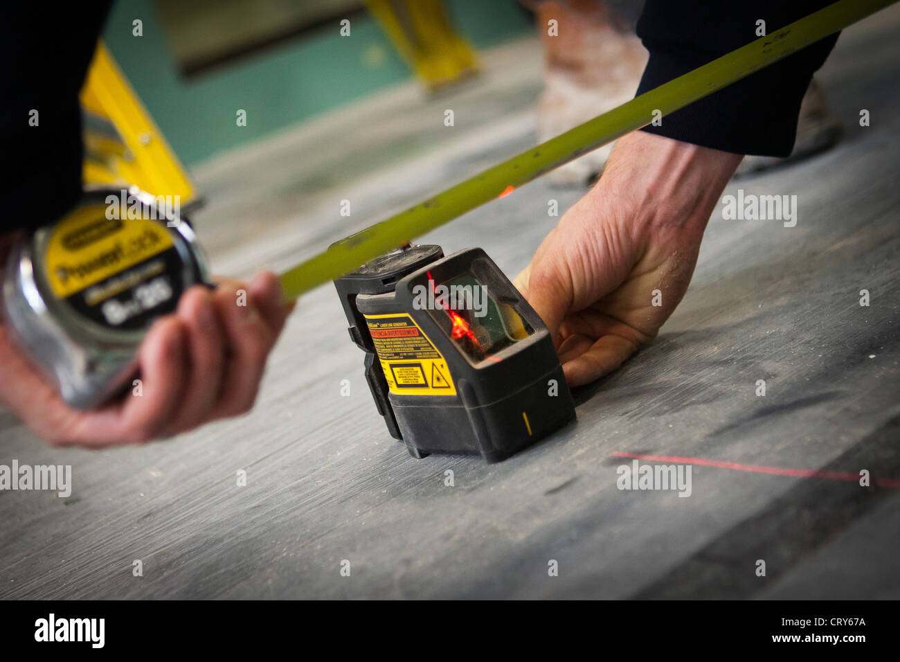 builders using a cross line laser Stock Photo Alamy