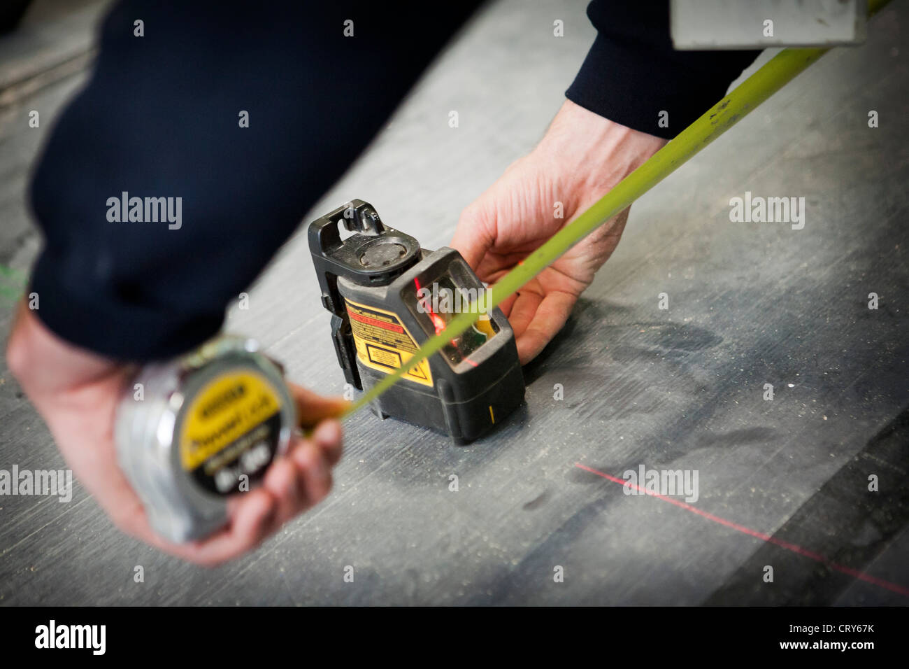 Builders using cross line laser Stock Photo Alamy