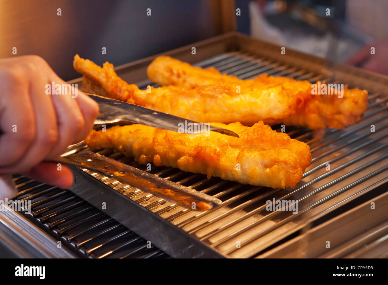Fried cod in batter ready to be served in chip shop, Goucestshire, uk Stock Photo