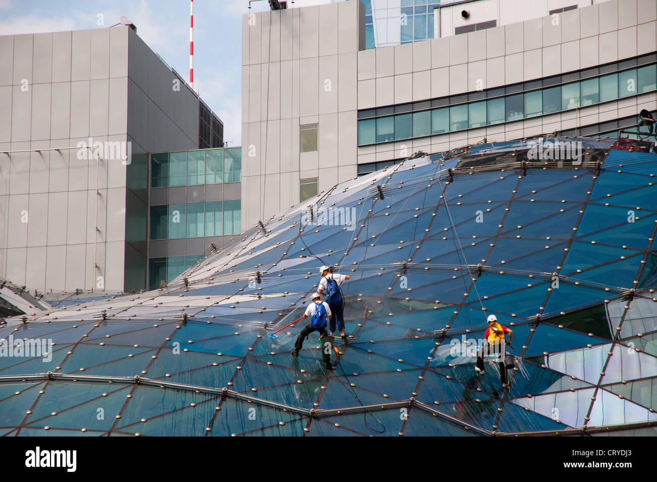 Men cleaning the roof of Zlote Tarasy shopping centre Srodmiescie the