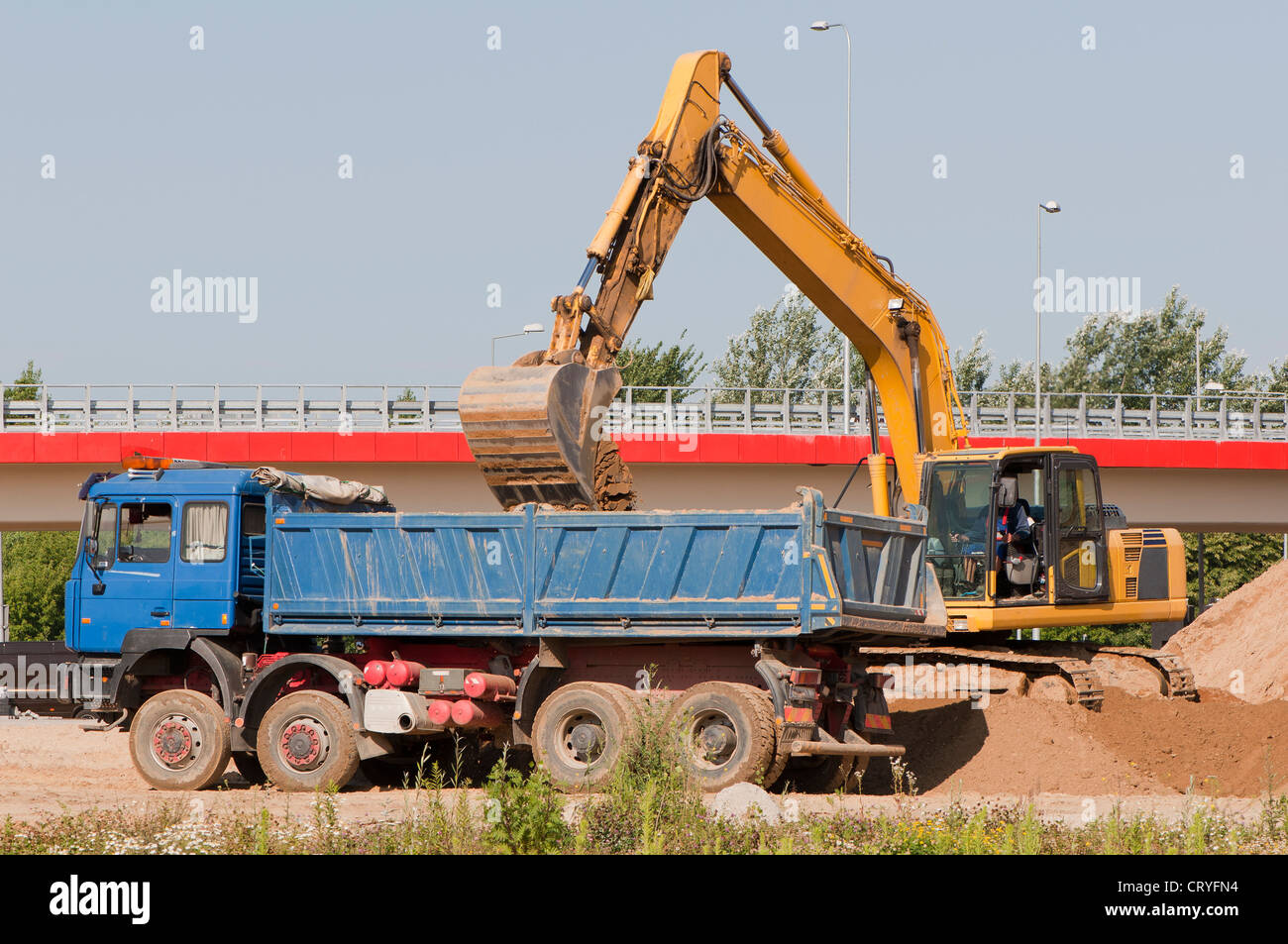 Excavator loading a truck on a construction site Stock Photo - Alamy
