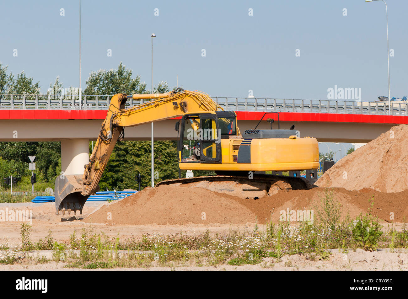 Yellow excavator on a hill Stock Photo