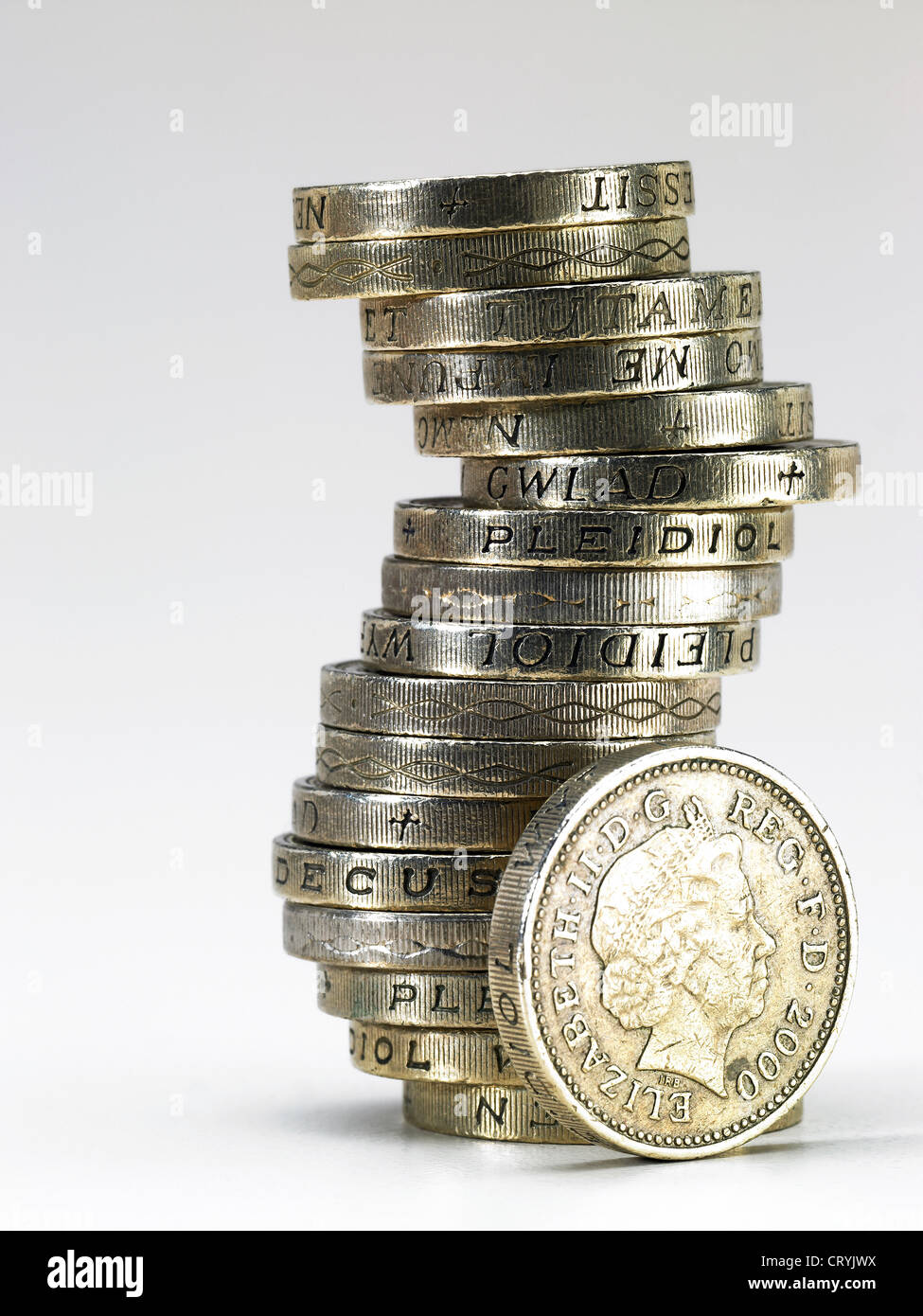 A pile of British pound coins with one by the side Stock Photo