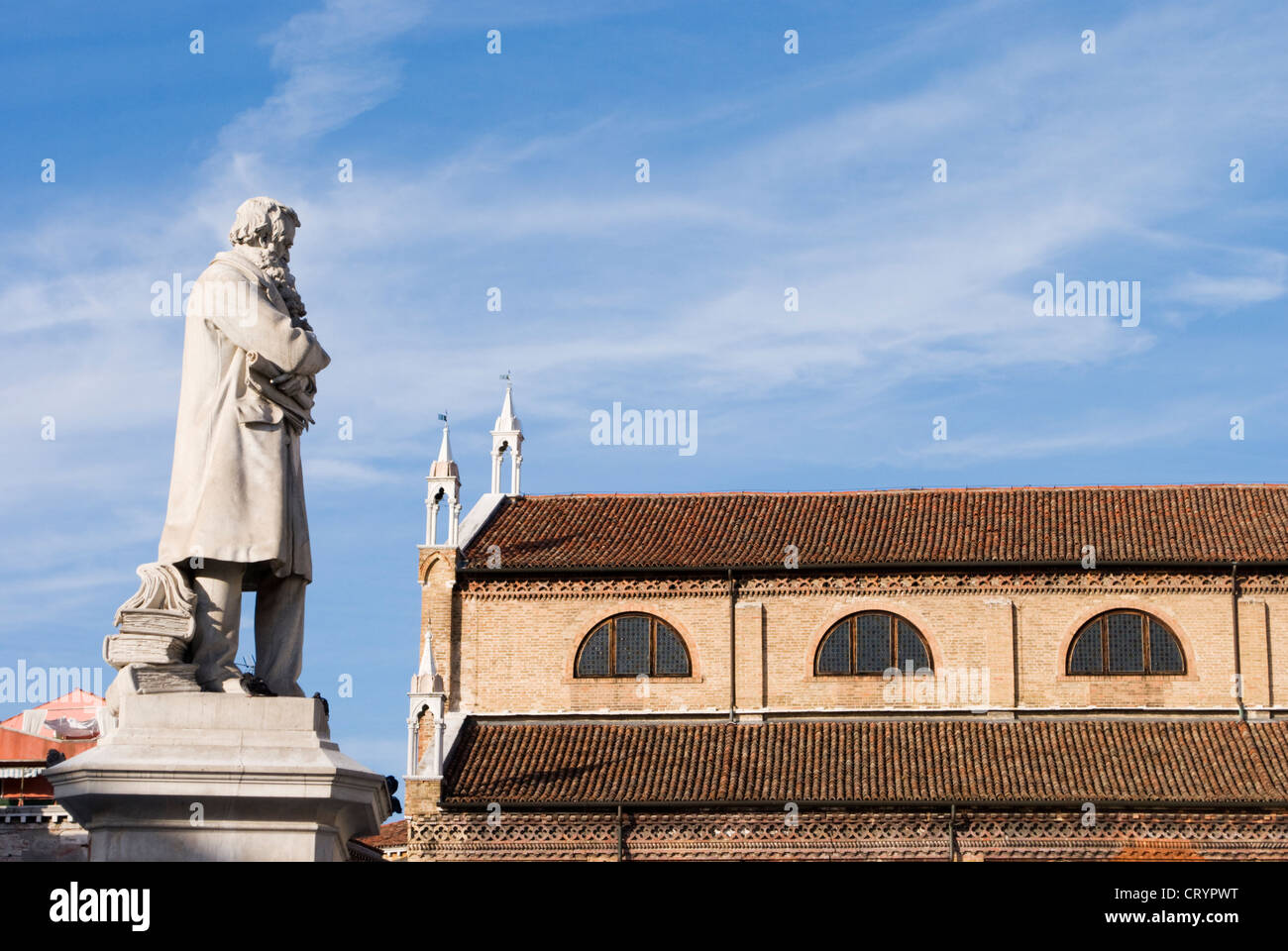 Niccolo Tommaseo statue in Campo San Stefano, Venice, Italy. Venetian statue overlooking church roof top Stock Photo