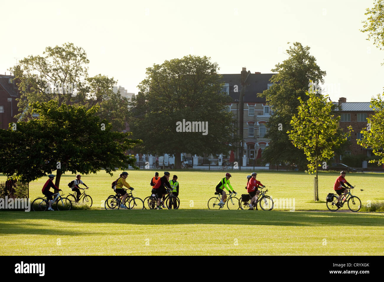 Cyclists in Clapham Common at sunrise heading for the start of a Charity Cycle ride, London UK Stock Photo