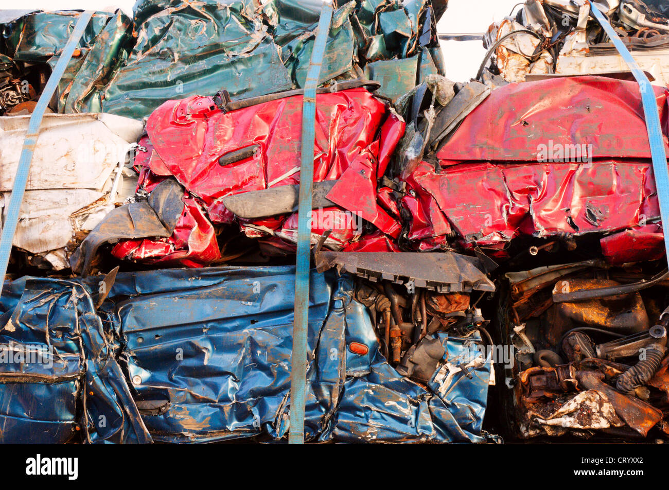 A pile of crushed car bodies strapped onto a transporter. Stock Photo
