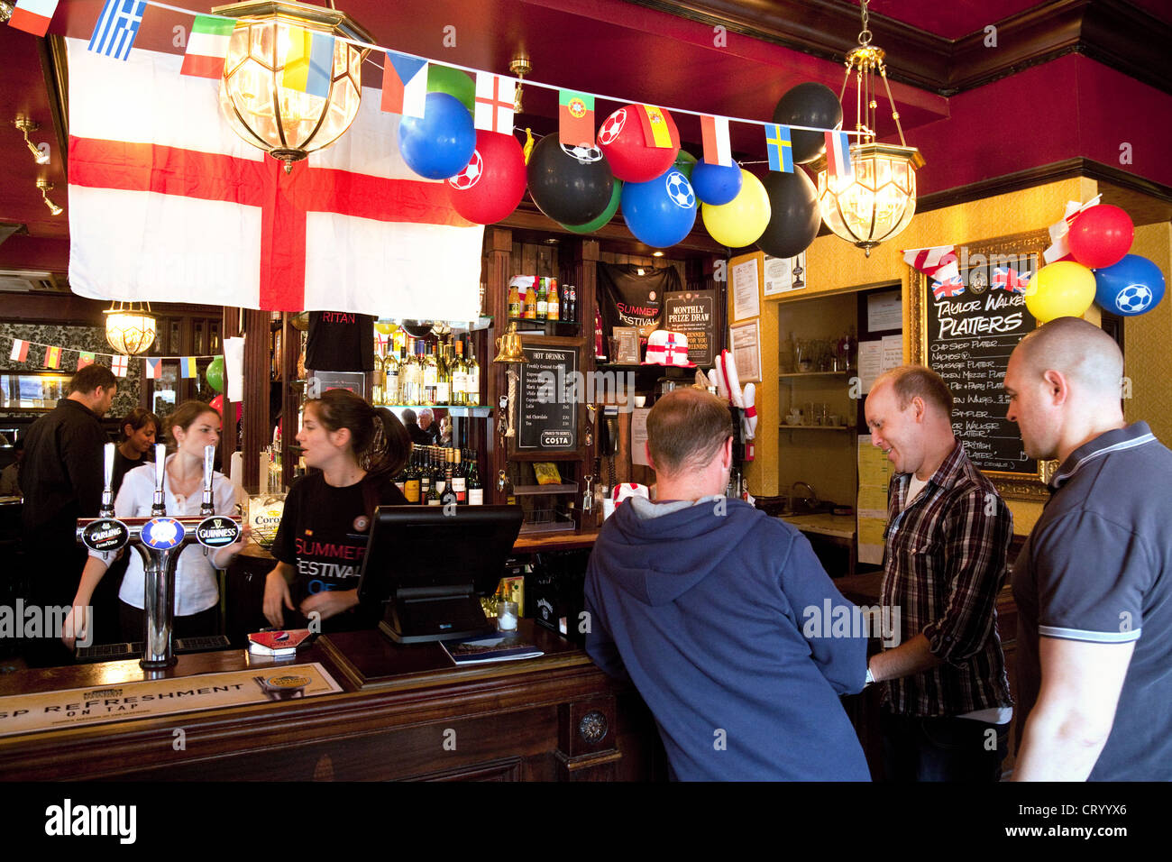 Three men ordering a drink in a bar, interior, Duke of York pub, Victoria, London UK Stock Photo