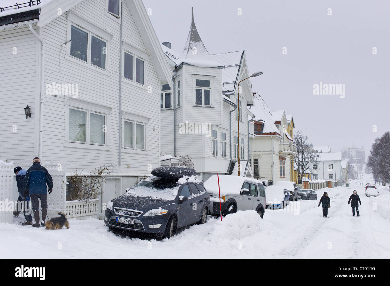 Street scene of couple walking their dog in Tromsoya, Tromso, Arctic Circle in Northern Norway Stock Photo