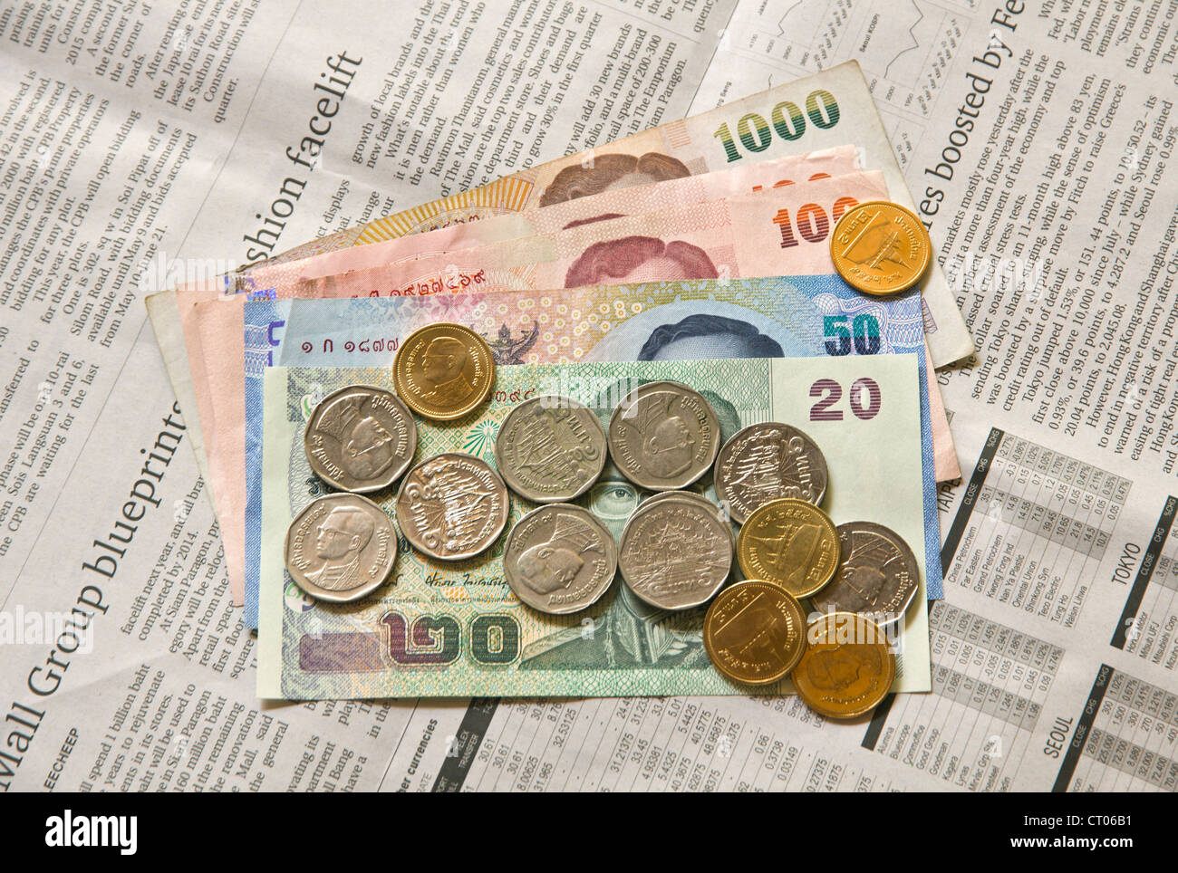 Thailand's Baht currency, Notes and coins on English Newspaper Stock Photo