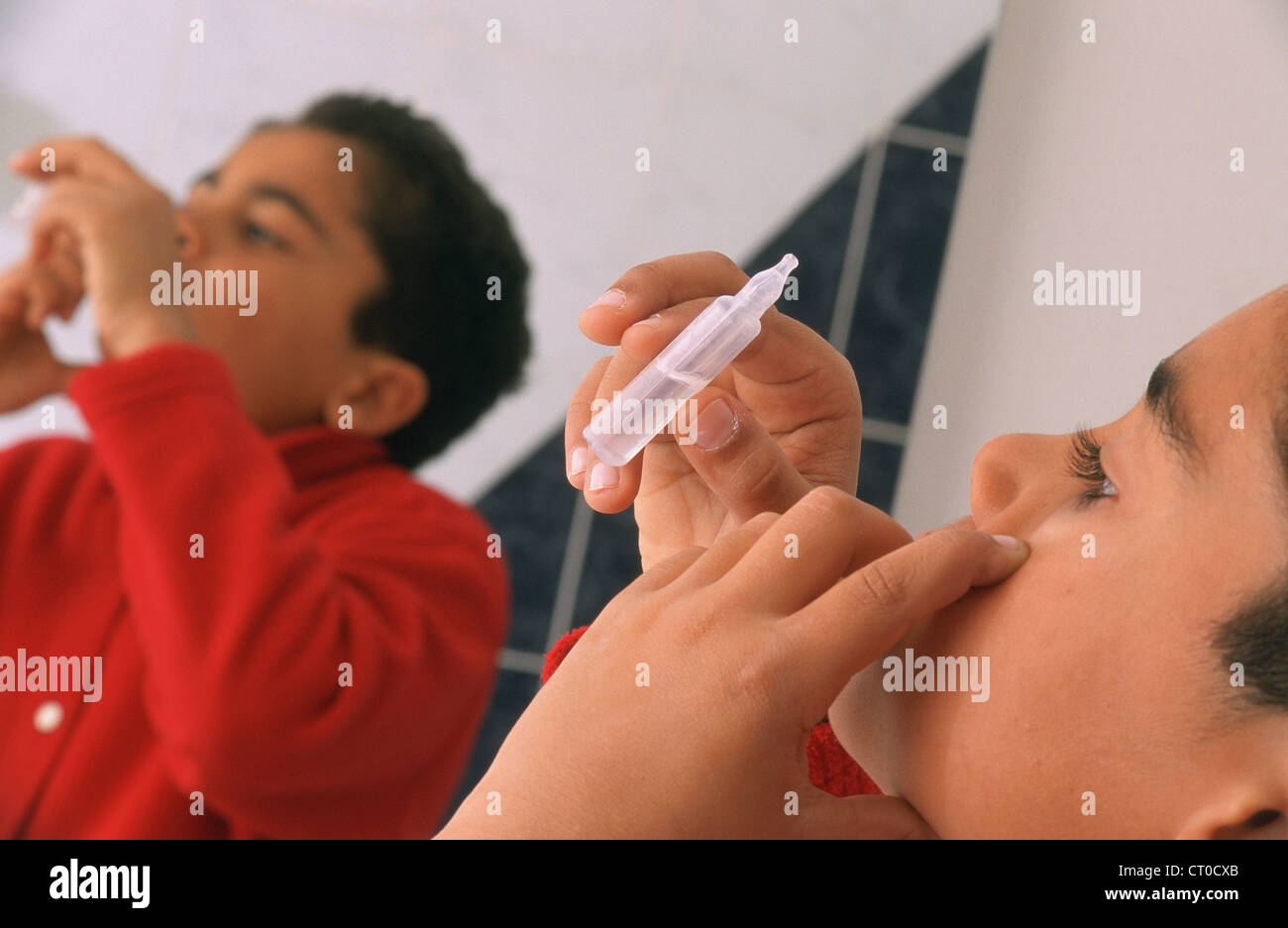 CHILD USING EYE LOTION Stock Photo Alamy