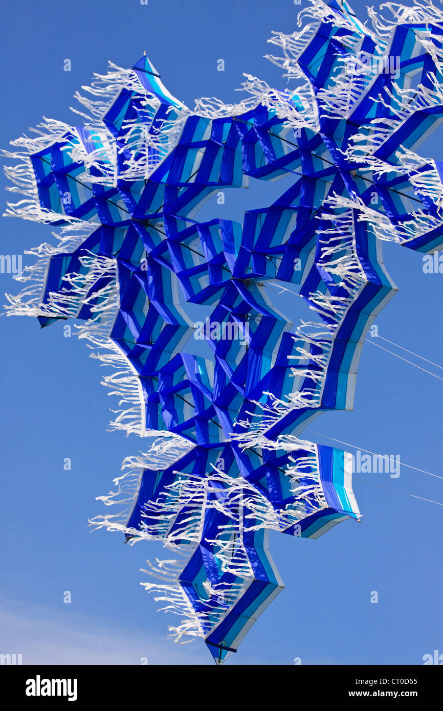 Brilliant blue colored kite riding high on a breeze Stock Photo - Alamy