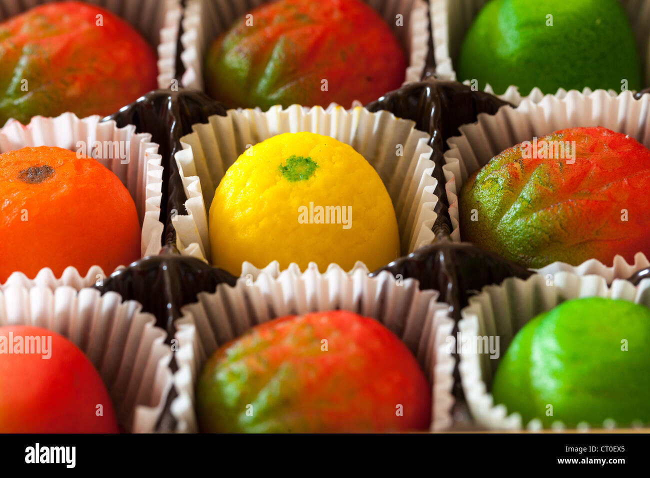 Fruit shaped candies in macro image of marzipan sweets in paper