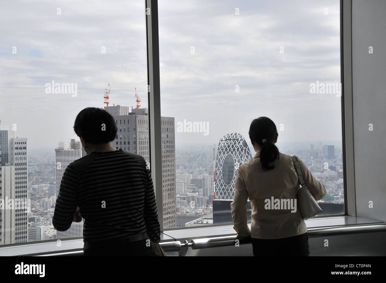 Visitors looking at view of Tokyo from observatory of Tokyo Metropolitan Government building Shinjuku Tokyo Japan Asia Stock Photo