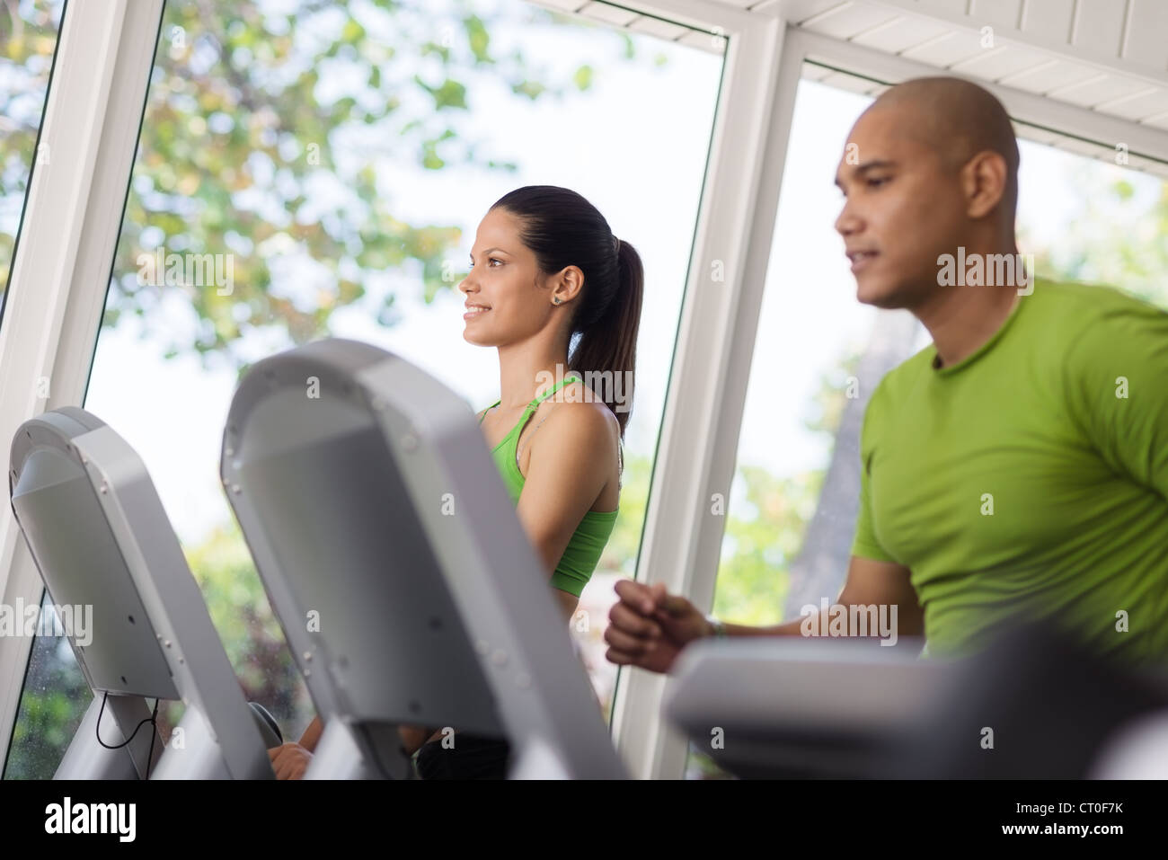 Man and woman working out and running on treadmill in fitness club ...