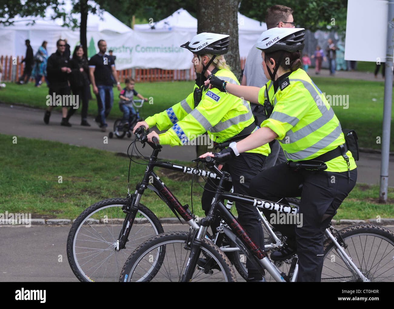 Two police women on bicycles patrol a city park Stock Photo - Alamy