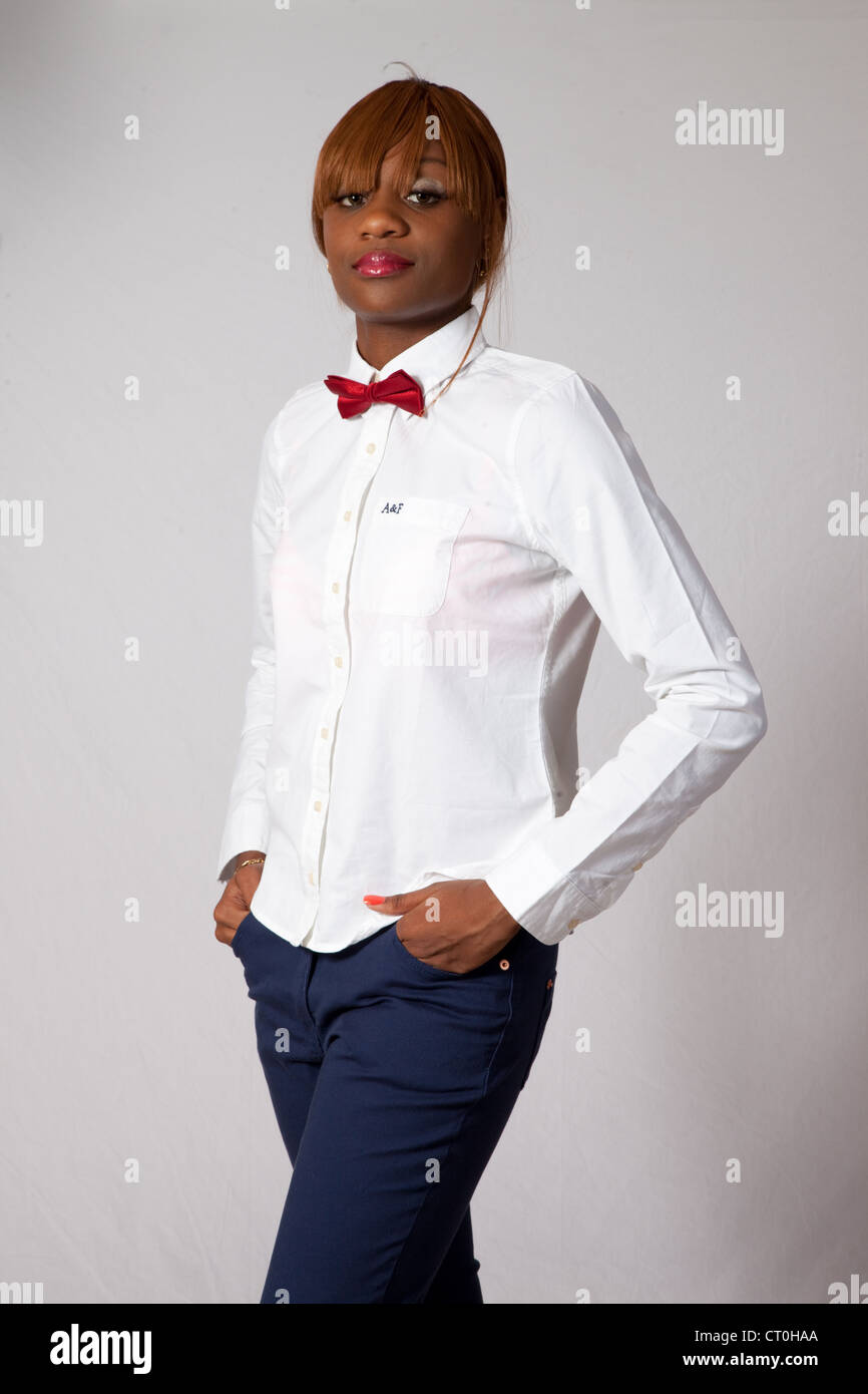 Lovely Black woman in white shirt, red bow tie and blue pants, standing ...