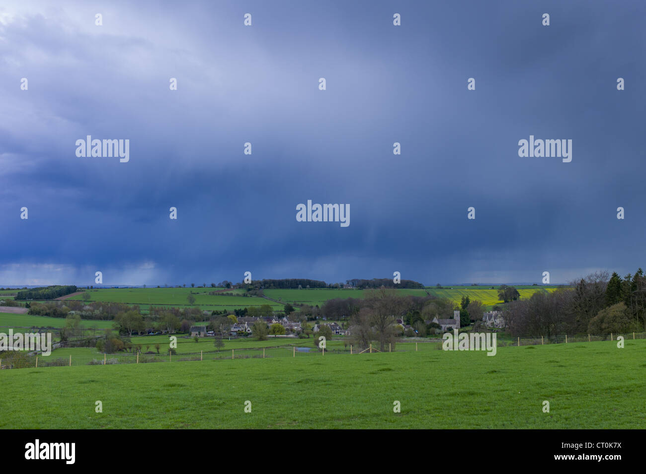 Rainstorm from Cumulonimbus cloud above Asthall Village in springtime in the Cotswolds, Oxfordshire, UK Stock Photo
