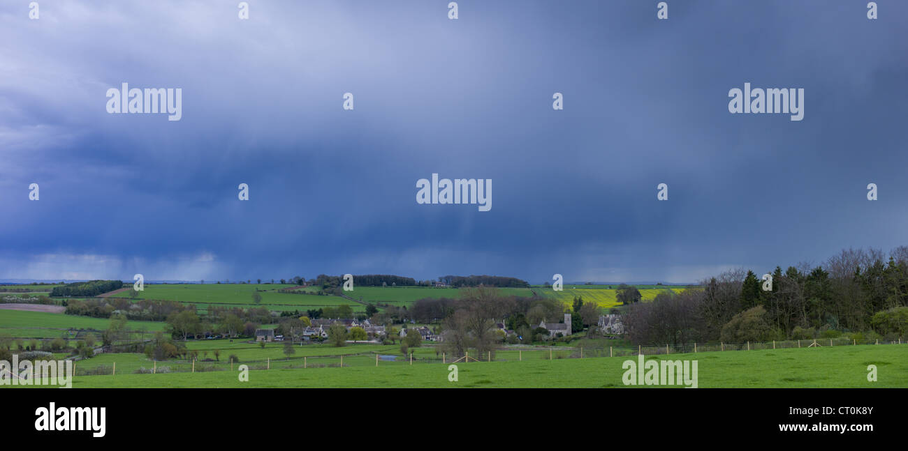Storm clouds in cloud formation above Asthall Village in springtime in the Cotswolds, Oxfordshire, UK Stock Photo