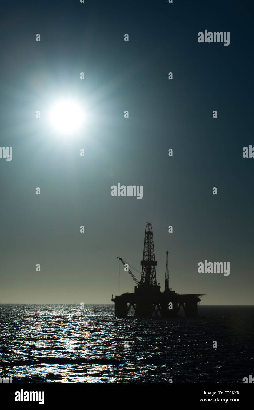 silhouette of an offshore oil drilling rig in low light sunset/sunrise time. Coast of Brazil Stock Photo