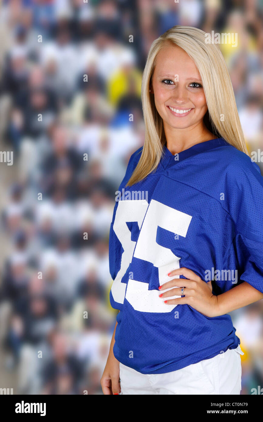 Teenage girl at a football game cheering for her team Stock Photo