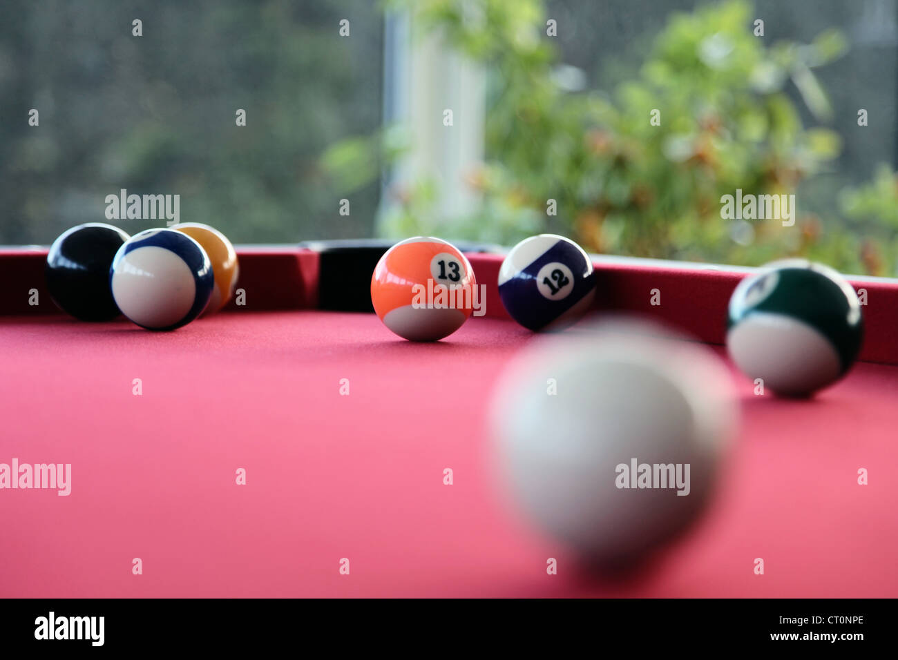 It's a photo of a snooker or billiard with a red carpet and few balls
